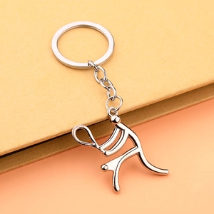 Detail shot of a creative metal tennis player keychain on an orange and yellow background