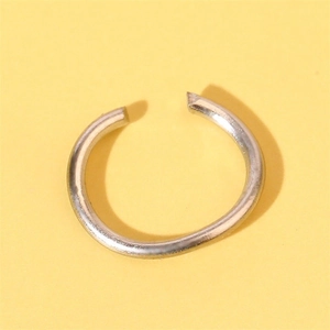 Close-up of minimalist silver metal open ring on a solid yellow background