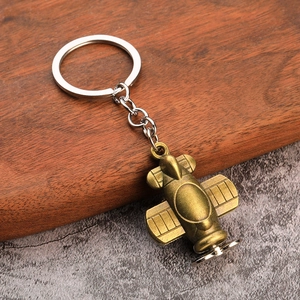 Retro bronze propeller plane metal keychain with antique finish on rustic wood