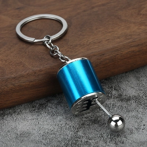 Macro detail of blue car shifter keychain showing the 6-speed gear shift pattern and lever