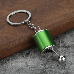 Close-up of a green manual gear shifter keychain model with movable silver lever