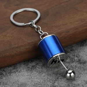 Detail of blue manual gear shifter keychain with movable lever on rustic wood background