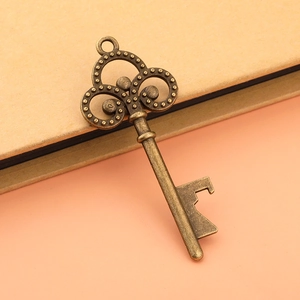 Macro view of vintage bronze key bottle opener showing intricate scroll details