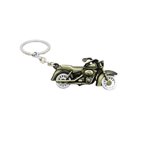 Vintage bronze motorcycle keychain with movable wheels on a clean white background