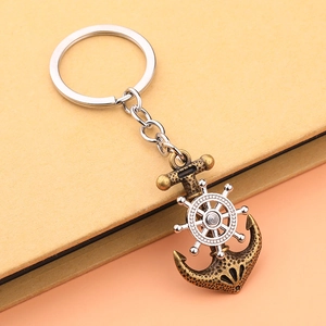 Retro maritime keychain with spinning helm and anchor pendant on rustic paper