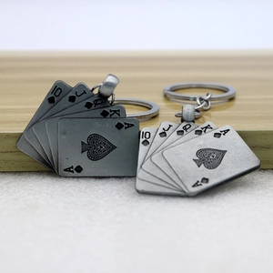 Vintage silver royal flush poker keychains featuring spade cards on wooden surface
