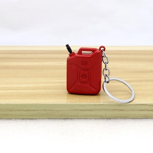 Miniature red 20L jerry can keychain model with silver ring on wooden surface