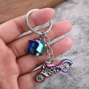 Detail of colorful rainbow plated motorcycle and helmet metal keychain held in hand