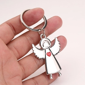 Close-up of silver angel wings keychain featuring a red heart pendant on metal ring