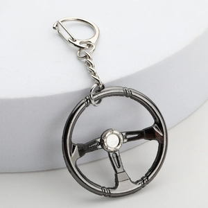 Gunmetal steering wheel model keychain with alloy metal finish on white background