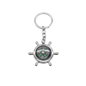 Nautical helm ship wheel compass keychain in polished silver metal with white background