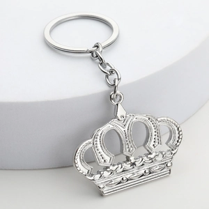 Elegant silver metal crown keychain with hollow design on white display stand