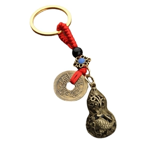 Chinese gourd keychain with brass Wu Di coins and red braided cord on white background