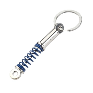 Miniature blue car shock absorber keychain with silver metal spring in a 45-degree view