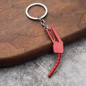 Detailed view of creative red fuel nozzle keychain on a rustic wood and stone surface