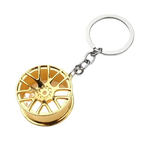 Golden alloy car wheel rim keychain with polished finish and metal chain link