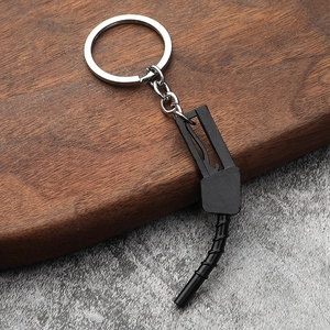 Creative fuel nozzle car keychain model in black and silver on a wooden background