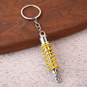Creative silver metal shock absorber keychain with bright yellow spring for car enthusiasts