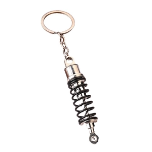 Car shock absorber keychain featuring a realistic silver metal finish and black spring coil