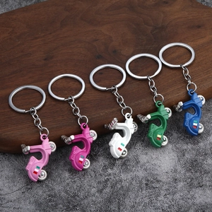 Creative scooter motorcycle keychains in five colors with Roma logo on wooden surface