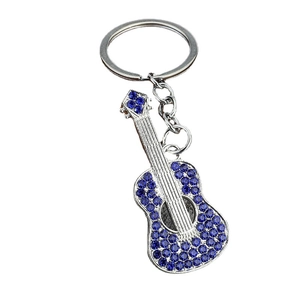 Guitar keychain in silver metal with deep blue rhinestones on a white background
