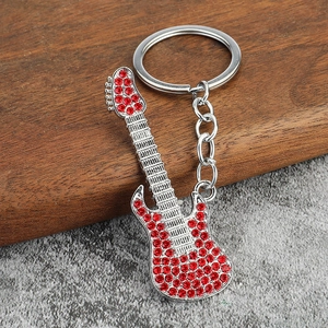 Macro shot of silver guitar keychain with sparkling red rhinestones and fine metal texture
