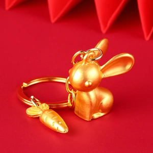 Golden Chinese zodiac rabbit keychain with small carrot charm on a vibrant red background