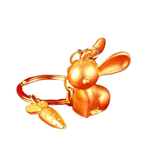 Golden rabbit zodiac keychain with a small carrot charm on a clean white background