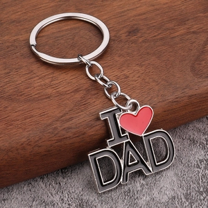 Close-up of I Love DAD silver keychain with red heart charm on a textured background