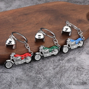 Three metal motorcycle keychains in red, green and blue with mini silver helmet charms