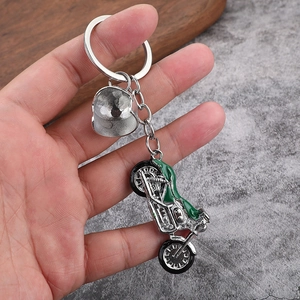 Creative motorcycle keychain with green enamel detailing and silver helmet charm pendant
