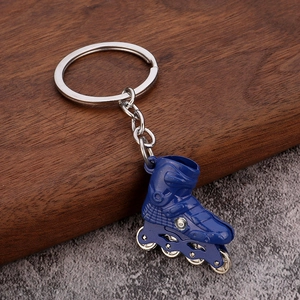 Detailed close-up of blue 3D roller skate keychain with functional metal wheels on a wooden surface