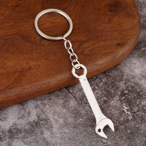 Close-up of industrial style silver metal wrench keychain with hex hole and link chain