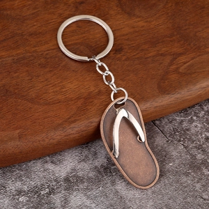Macro detail of flip-flop keychain with bronze brushed sole and silver strap
