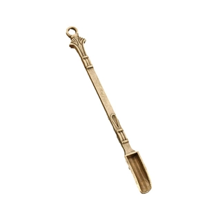 Vintage 80mm gold metal snuff spoon with decorative ring handle on white background