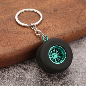 Creative 3D car tire keychain with green wheel rim on wood surface, high-quality miniature
