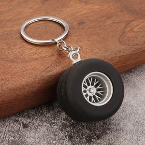 Detail view of mini car tire keychain with black rubber tread and silver metal wheel hub