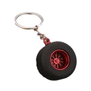 Realistic black rubber tire keychain with a red racing wheel hub on white background