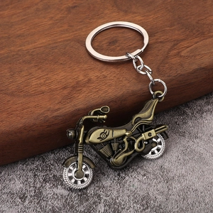 Vintage bronze alloy motorcycle keychain for men and women on a rustic wood background
