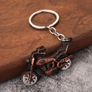Vintage bronze alloy motorcycle keychain on a wooden base with a cool industrial design