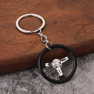 Racing steering wheel keychain model made of silver polished metal and matte black rubber
