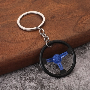 Macro detail of a racing steering wheel keychain with blue metallic finish and black rim