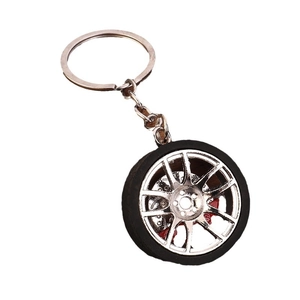 Car tire keychain with silver alloy wheel hub and red brake caliper on white background