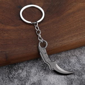 Porte-clés couteau karambit en métal avec finition galvanisée gris foncé sur bois