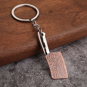 Macro shot of miniature silver and copper cleaver keychain with realistic metal textures