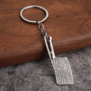 Detailed view of metal kitchen cleaver keychain with Damascus steel pattern texture