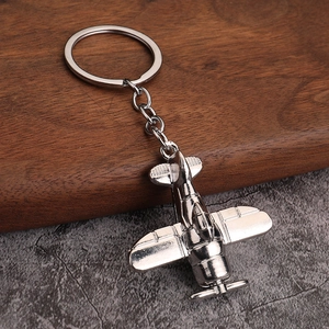 Porte-clés avion vintage en métal argenté avec ailes et hélice sur socle en bois