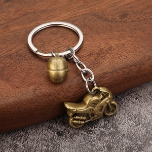 Vintage alloy motorcycle keychain with helmet pendant on rustic wooden background