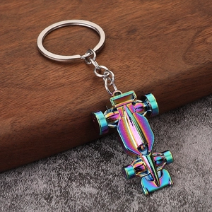 F1 racing car keychain with rainbow plating and metallic finish on a textured surface