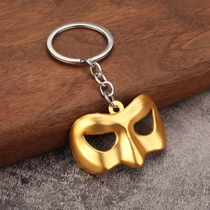 Golden movie mask keychain with a matte finish and a durable silver metal keyring